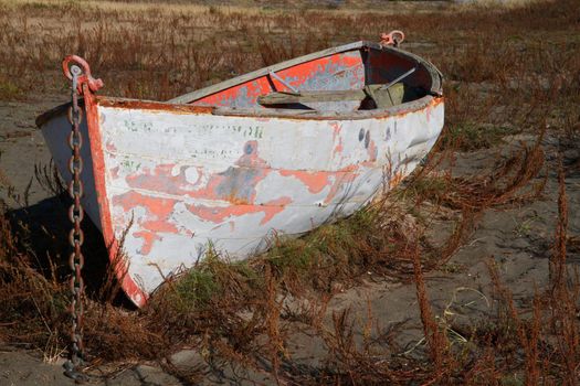 HDR image of a red and white Land locked Boat  on sand dunes 