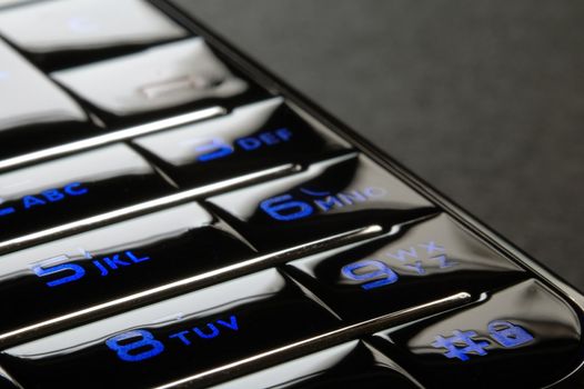 Close up shot of blue mobile keypad under dark environment