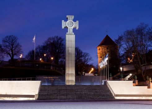 Night time floodlit image of the new glass war memorial and monument in Tallinn Estonia with the old castle walls and tower in background