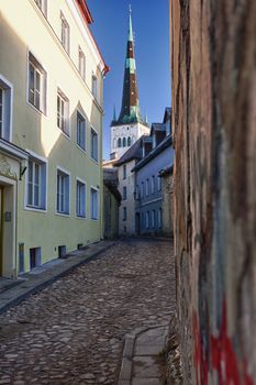 Old street in Tallinn Estonia showing cobbled road and the old church