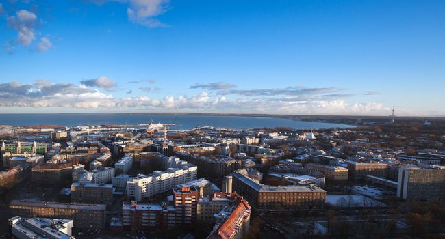 View over the city of Tallinn in Estonia towards the Baltic sea showing the modern parts of the town and the port