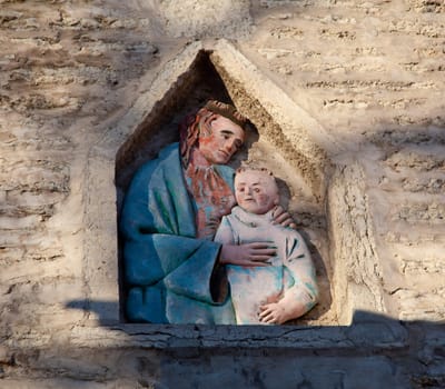 Carving of Jesus and child in an old wall in Tallinn Estonia on the climb to Toompea