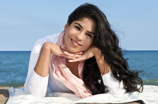 Portrait of beautiful smiling native american girl laying at beach