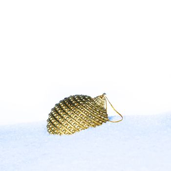 golden christmas bauble in snow