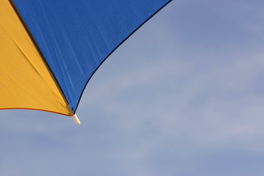 yellow and blue parasol with copy space in the sky area