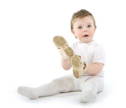 Child with shoes sitting. Isolated on white