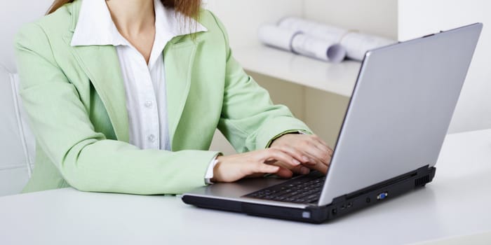 The woman works with the computer on a workplace at office