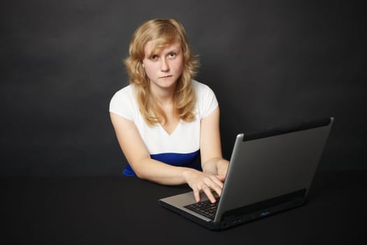 The young woman with the laptop works in the Internet in the evening