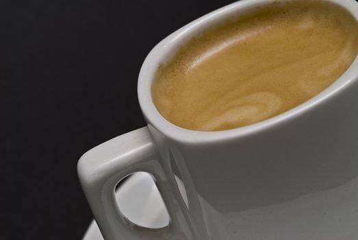 A cup of coffee on a black background.