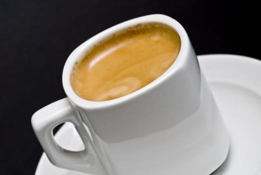 A cup of coffee on a black background.