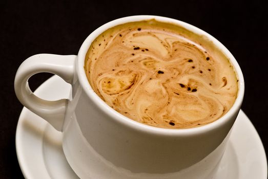 A cup of coffee on a black background.