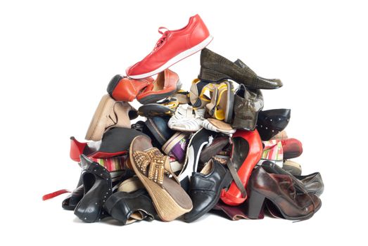 Huge pile of female and male second-hand shoes. Isolated on white background
