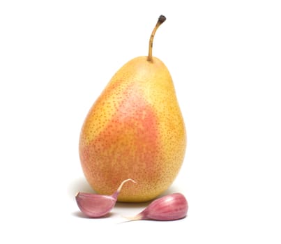 Pear and two segments of garlic on a white background.