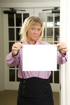 woman with a sign standing in a doorway