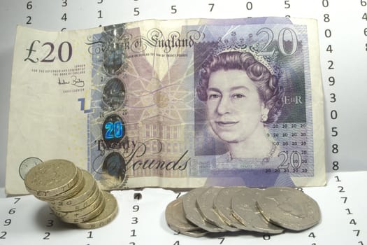 Twenty pound note with coins