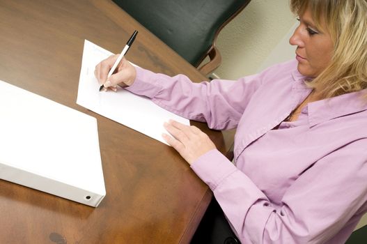 a woman writing notes for a team meeting