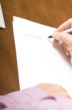 womans hands writing notes on a paper with a pen