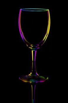 transparent colored empty wine glass, isolated on black