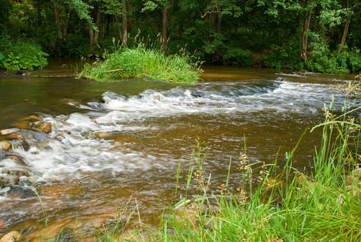 beautiful low waterfall in forest