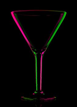 transparent colored empty martini glass, isolated on black