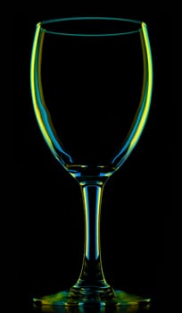 transparent colored empty wine glass, isolated on black