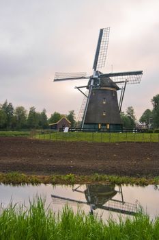 Dutch mill, build anno 1621, in farmland on cloudy morning after sunrise