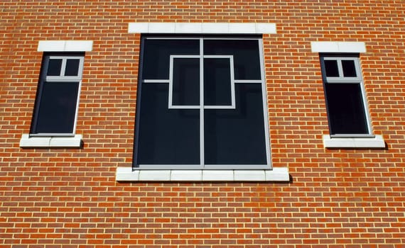 three window and simple brick wall architecture