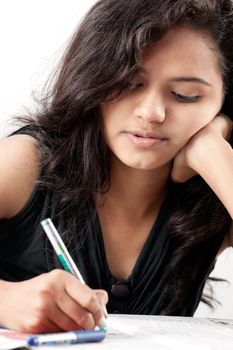 Beautiful indian girl is writing a test and thinking