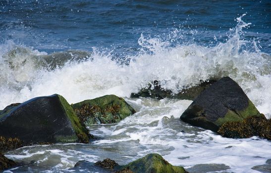 Rocks with breakers at the coast on sunny day