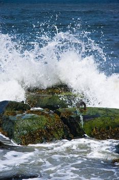 Breakers on basalt rocks at the coast on sunny day