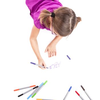 Girl lying on floor and making drawings on paper
