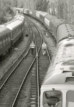 two distant workers walking on railroad tracks