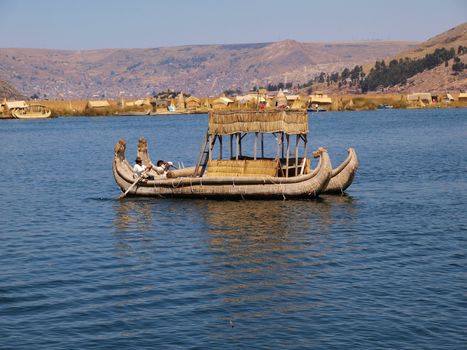 thatched boat with locals on the lake Titicaca, Peru
