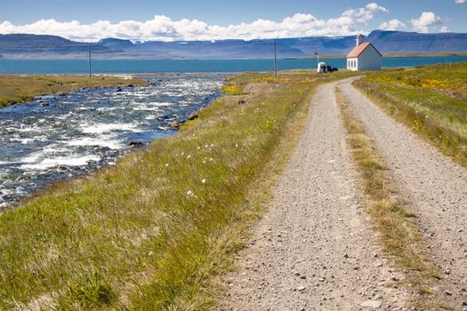 River, gravel route, old white church - Unadsdalur, Iceland. Summerday