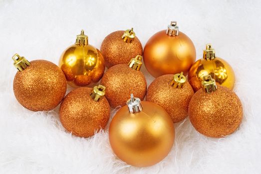Christmas golden orange spheres on a white fur