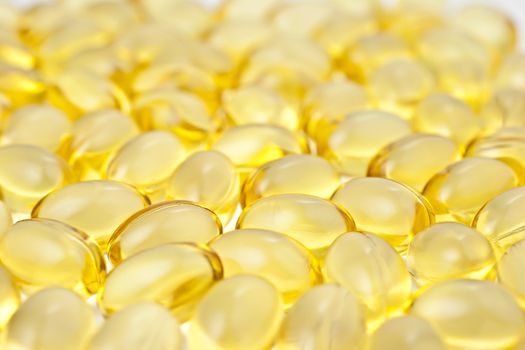 Nutritional supplement pills in warm colors and shallow depth of field. The yellow ones are vitamin E and cod liver oil. 
