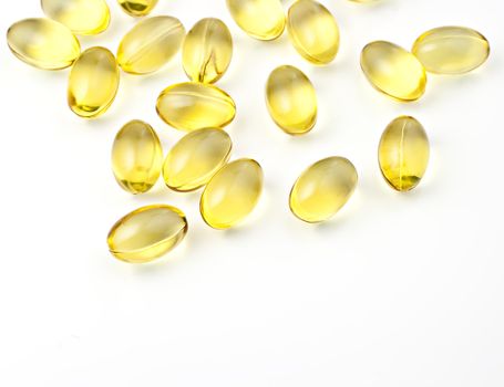 Nutritional supplement pills in warm colors and shallow depth of field. The yellow ones are vitamin E and cod liver oil.