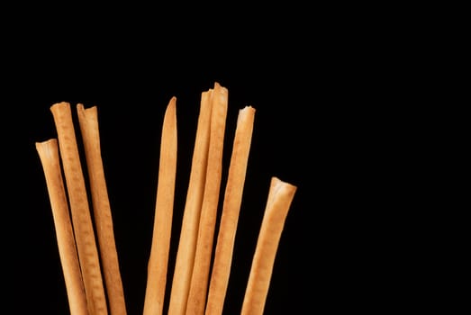 A bunch of grissini, Italian breadsticks, isolated on black