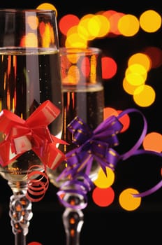 two wineglasses with a champagne on a background of multicoloured sparks