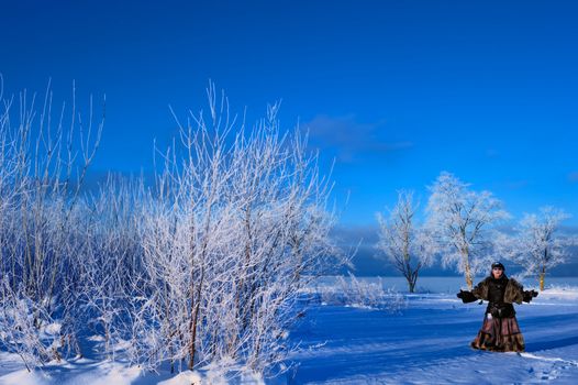 A woman stands in the middle of a snowy field