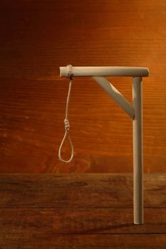 Gibbet with loop on gloomy wooden background