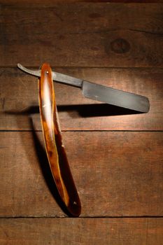 Very old rusty classic straight razor on wooden background