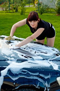 Adult cleaning her car outside