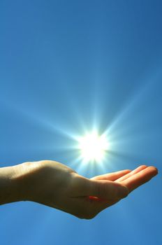 hand sun and blue sky with copyspace showing freedom or solar power concept
