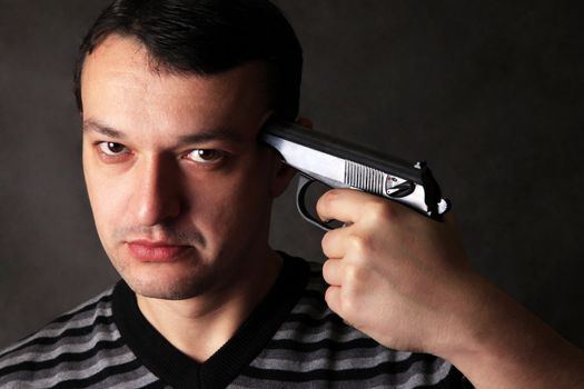 The man with a pistol on a dark background