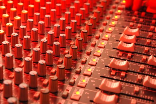 music soundboard under red stage lighting