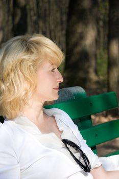 Beautiful blond woman sitting outdoors