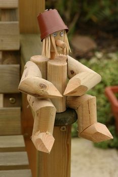 little man made from wooden logs with straw for hair
