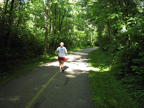 A photograph of a person running along a trail.