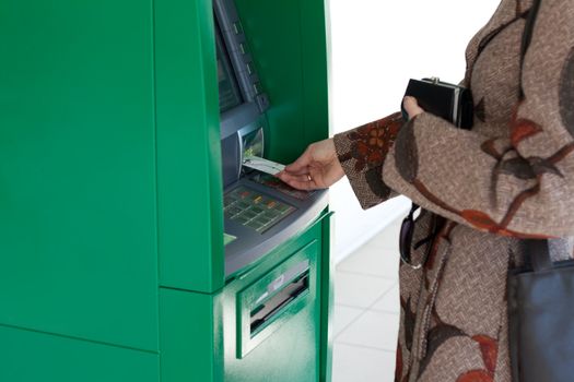 Girl uses bank terminal with credit card